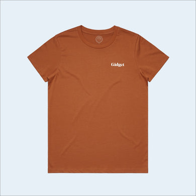 Women's copper colored t-shirt, view of front-side, with small print of g-fin logo